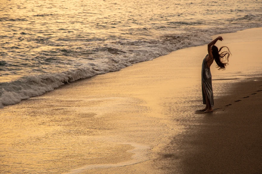 Distant figure arching backwards on a golden shoreline at sunset, Sabina in Tenerife personal project photographed by Ina Cenusa