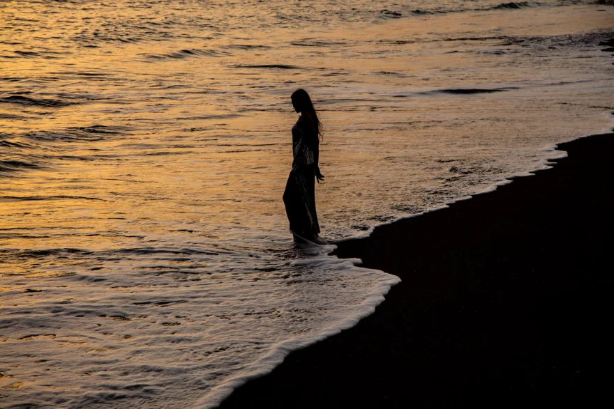 Silhouette walking through the shallows against a golden sunset, Sabina in Tenerife personal project photographed by Ina Cenusa