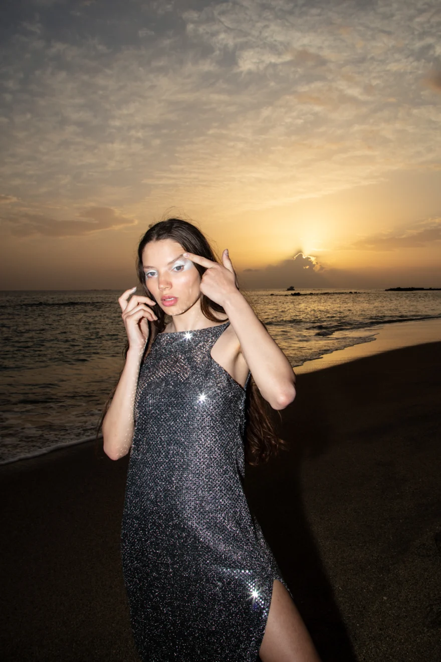 Model in a silver sequinned dress against the setting sun over the sea, Tenerife, Sabina in Tenerife personal project photographed by Ina Cenusa