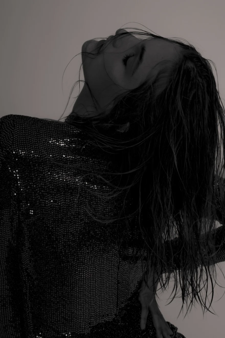 Black and white image of hair swept across the face over a sequinned dress, Iso Model Management editorial photographed by Ina Cenusa