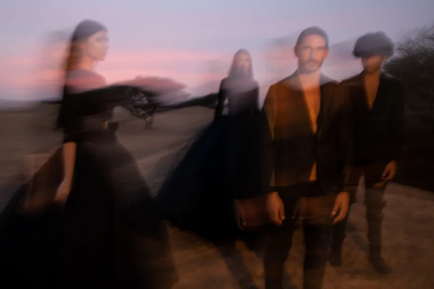 Long-exposure group shot against a pink desert sky, closing image of the campaign, Philip Martin's campaign photographed by Ina Cenusa