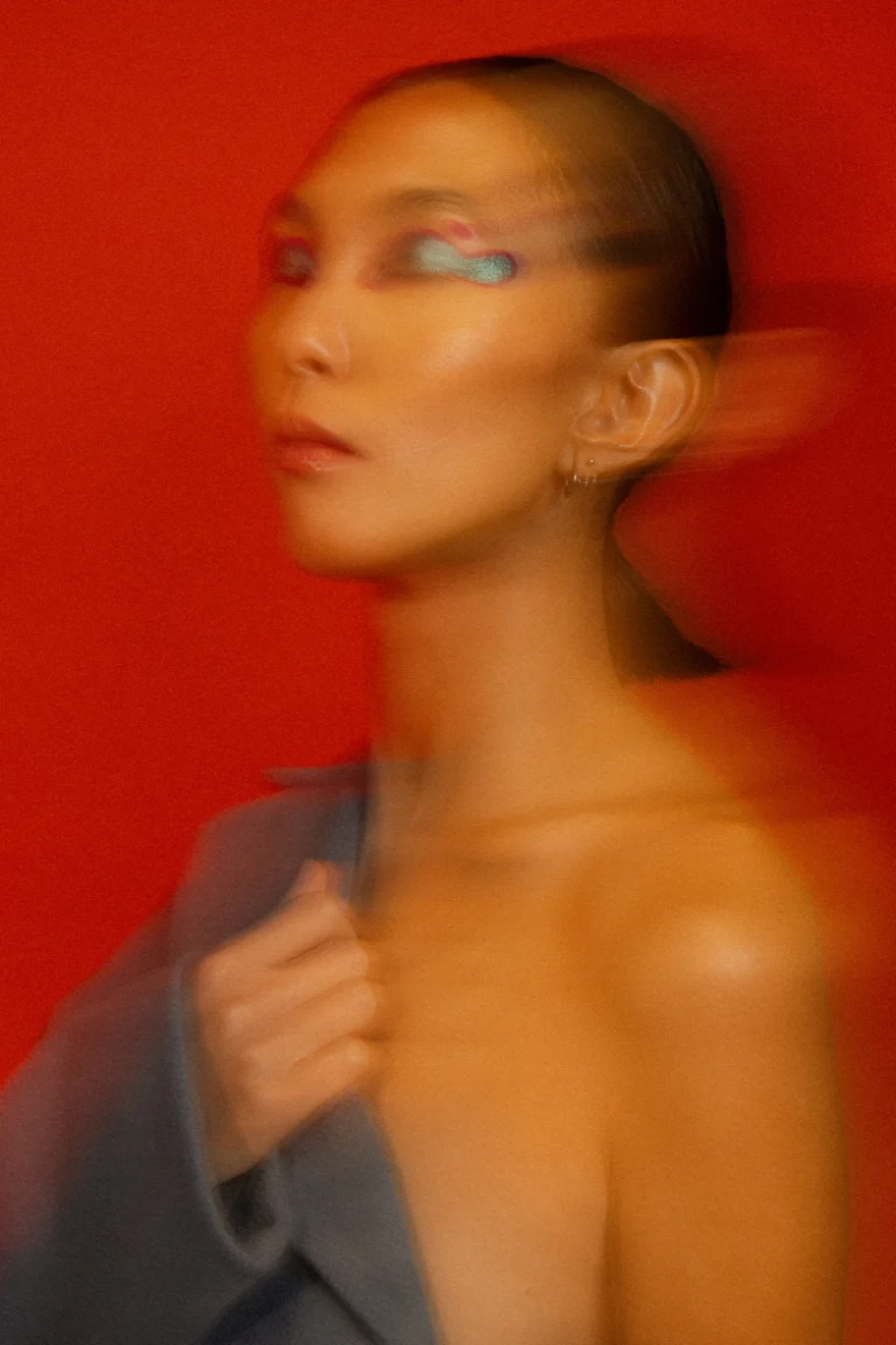 Motion-blurred portrait in a blue-grey look against red, LYX Magazine editorial photographed by Ina Cenusa