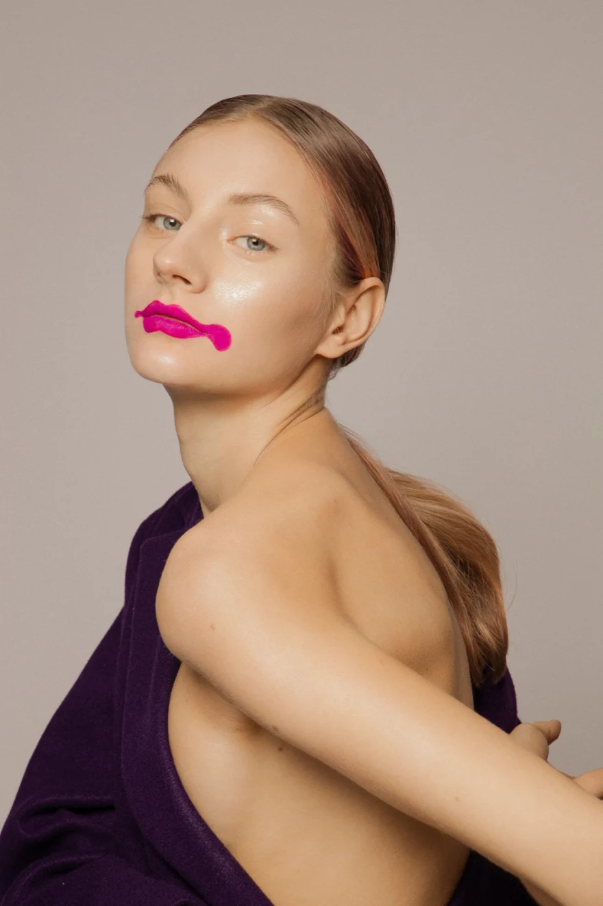 Model in a purple dress with a graphic fuchsia lip, closing image of Metamorfosis, LYX Magazine editorial photographed by Ina Cenusa