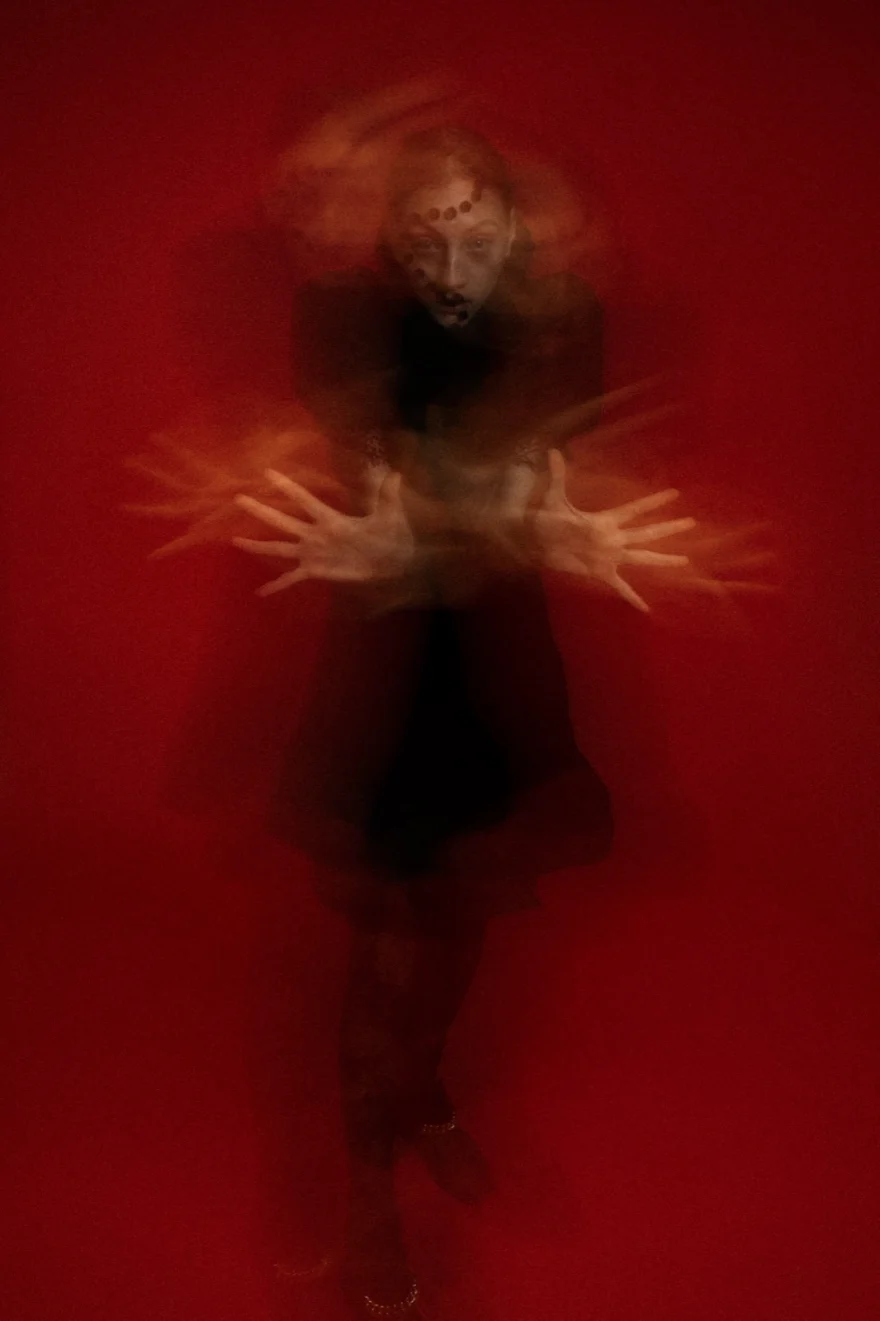 Long-exposure figure in black against a red backdrop, LYX Magazine editorial photographed by Ina Cenusa