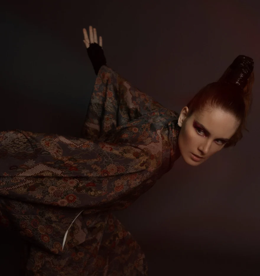 Model leaning sideways in a patterned kimono coat under warm low light, Hunter Magazine editorial photographed by Ina Cenusa