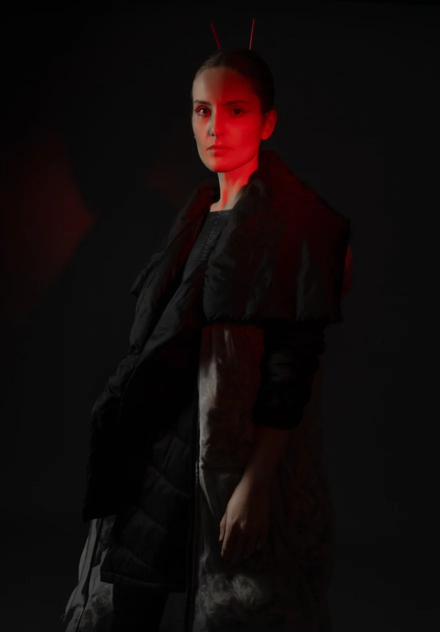 Model in a dark textured coat lit by deep red light, Hunter Magazine editorial photographed by Ina Cenusa