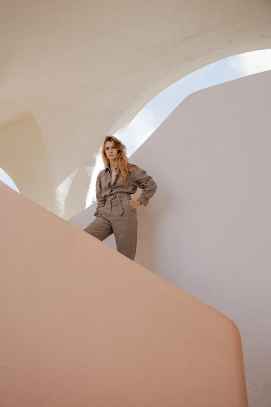 Model in a linen jumpsuit framed by the white curved architecture of Costa Smeralda, Costa Smeralda Magazine editorial photographed by Ina Cenusa