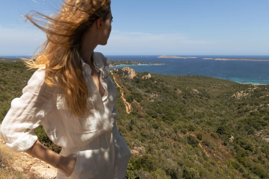 Model in a windswept white linen shirt overlooking the Costa Smeralda coastline, Costa Smeralda Magazine editorial photographed by Ina Cenusa