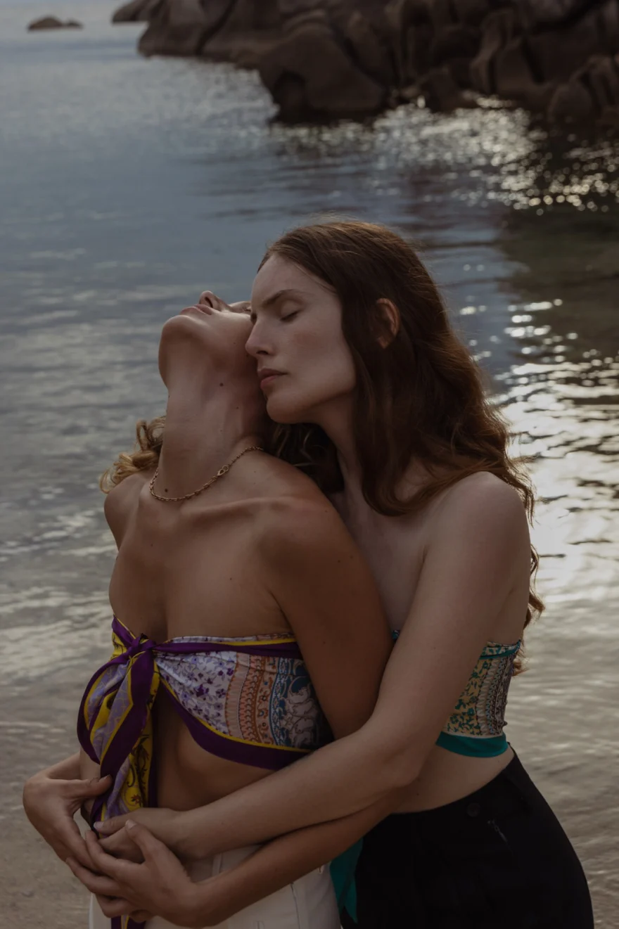 Two models embracing at the water's edge at dusk, SHOT Magazine editorial photographed by Ina Cenusa