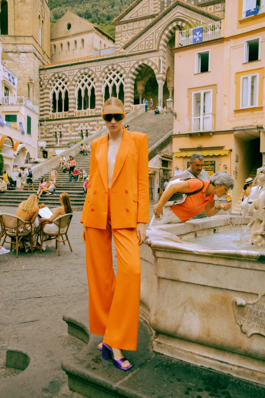 Model in a bright orange suit in front of the Amalfi cathedral, Amalfi Coast personal project photographed by Ina Cenusa