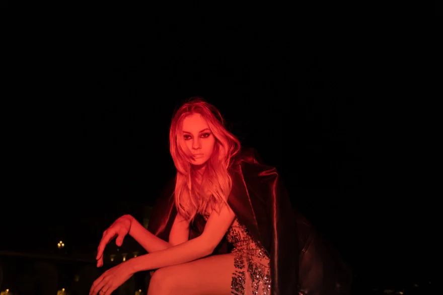 Model seated outdoors at night lit in deep red, Amalfi Coast personal project photographed by Ina Cenusa