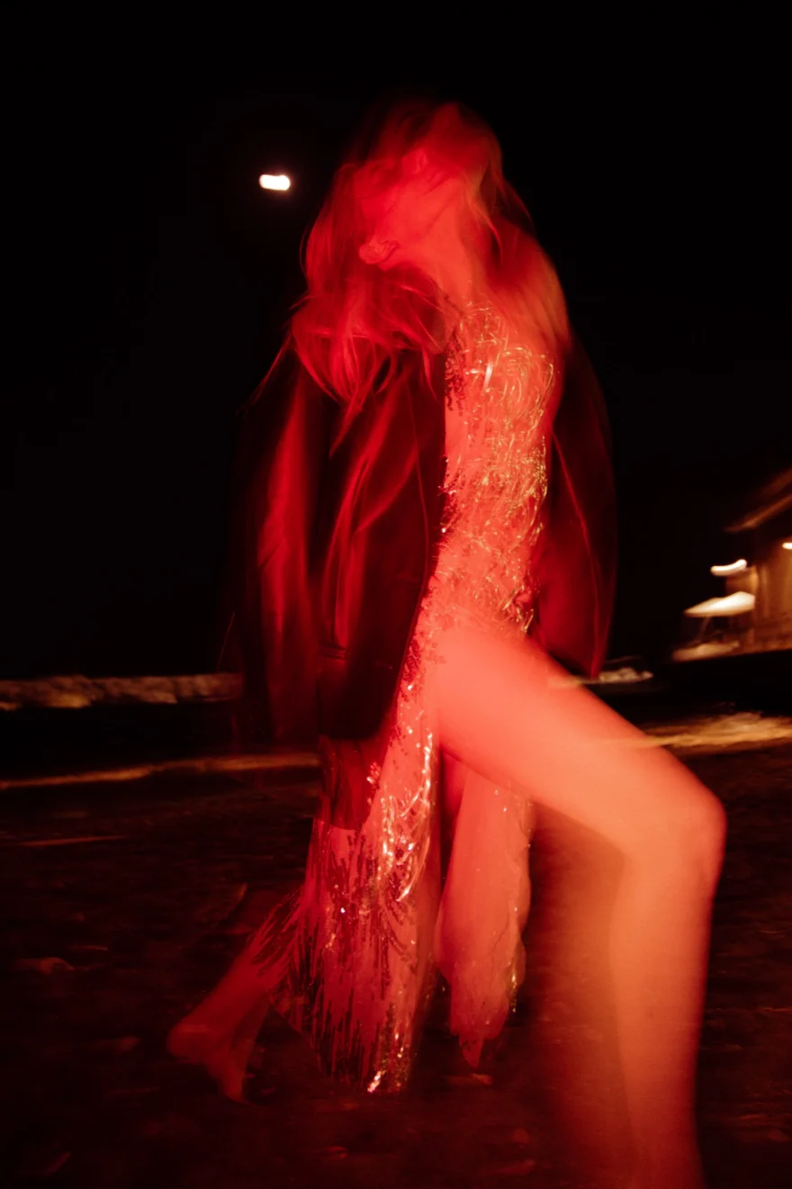 Model in a sequinned dress under red light at night, Amalfi Coast personal project photographed by Ina Cenusa