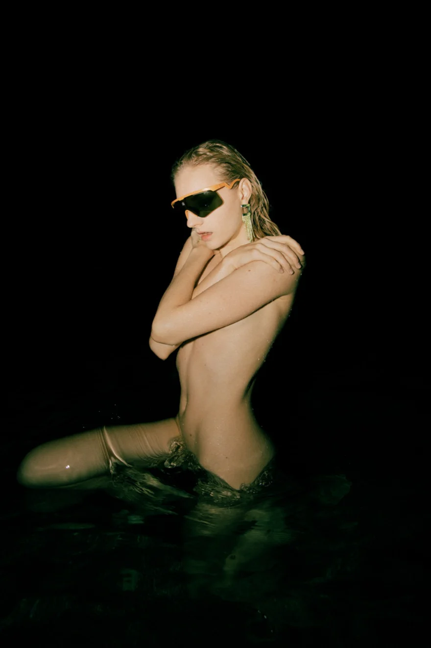 Model kneeling in dark water with arms crossed, Amalfi Coast personal project photographed by Ina Cenusa