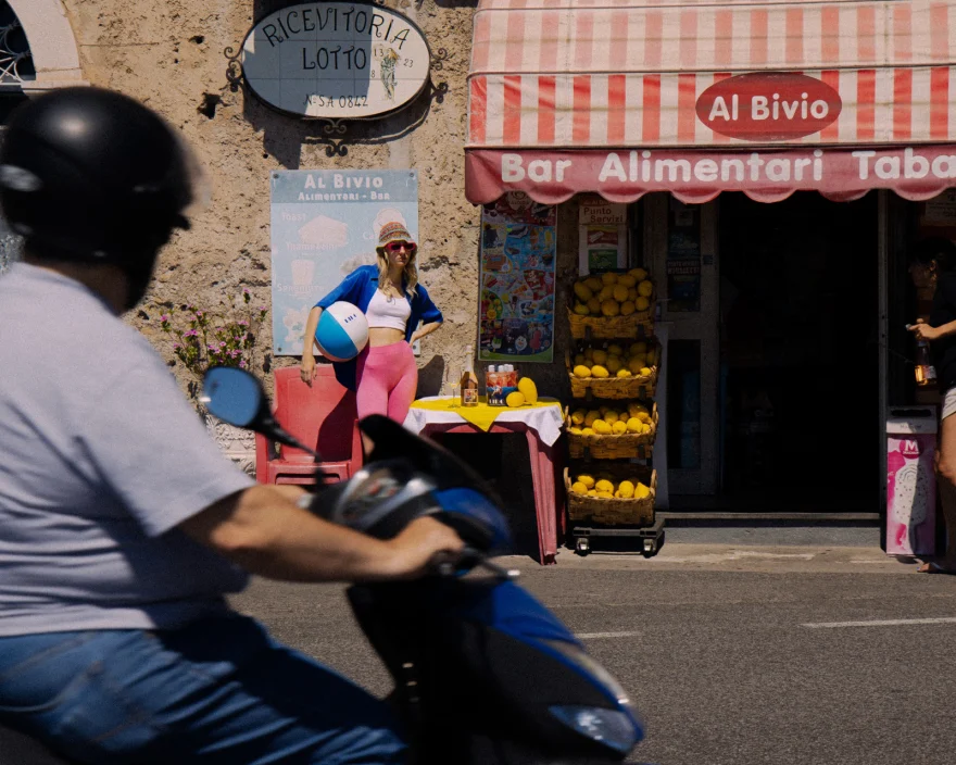 Scooter passing a village bar in the summer heat, Canella Wine campaign photographed by Ina Cenusa