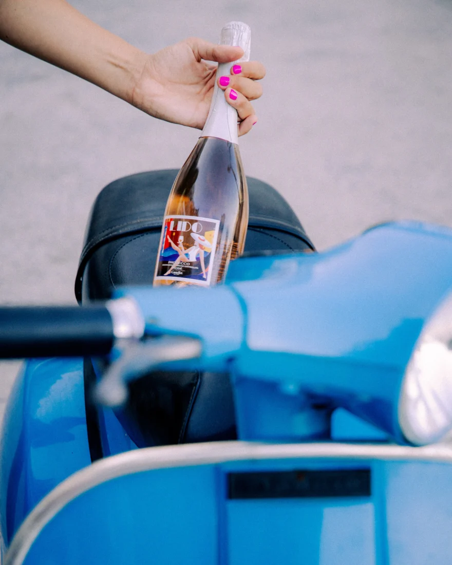 Hand holding a chilled bottle of rosé, Canella Wine campaign photographed by Ina Cenusa