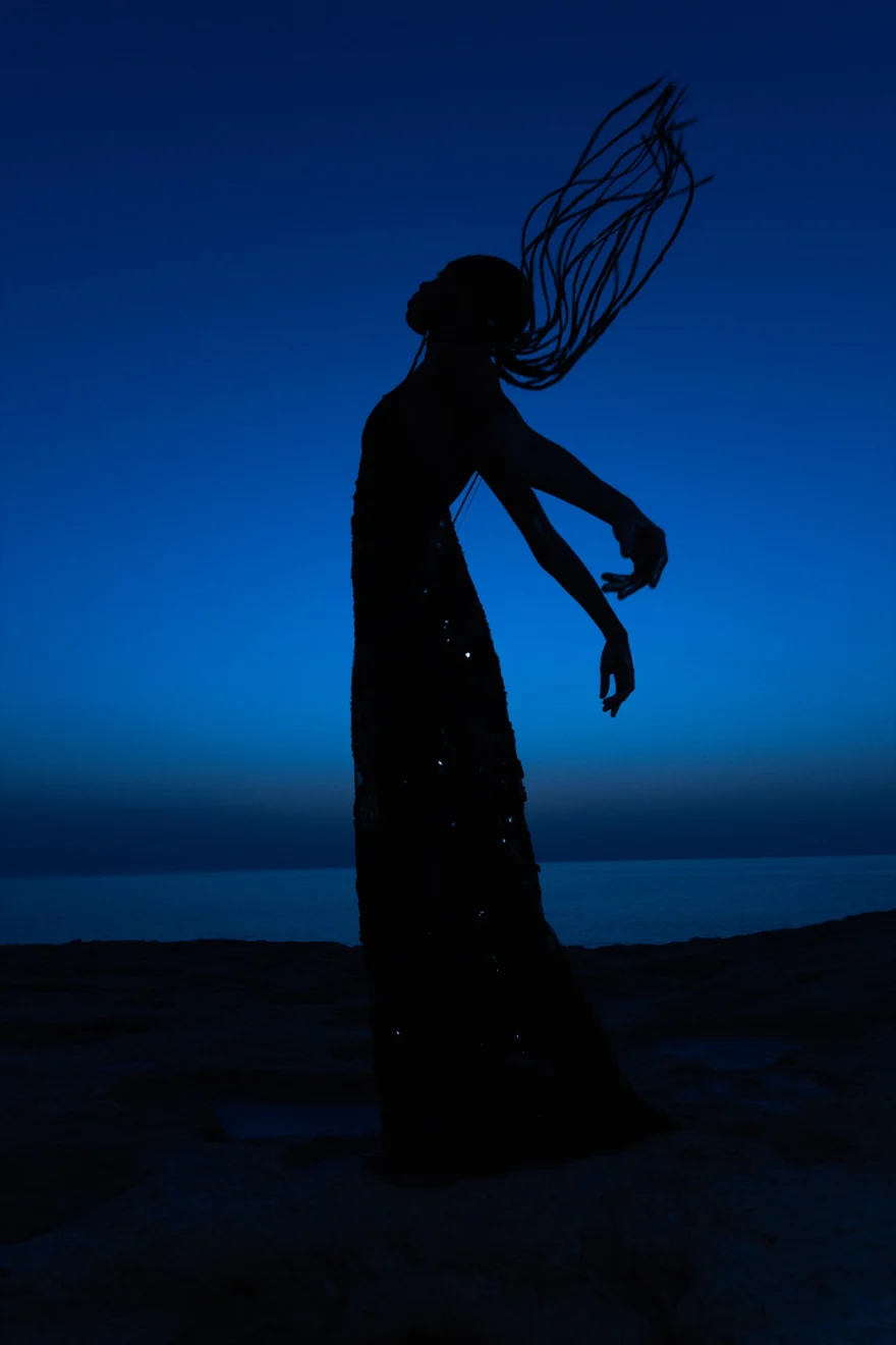 Silhouette with braids in motion against a deep blue night sky, Ermanno Scervino × SHOT Magazine editorial photographed by Ina Cenusa