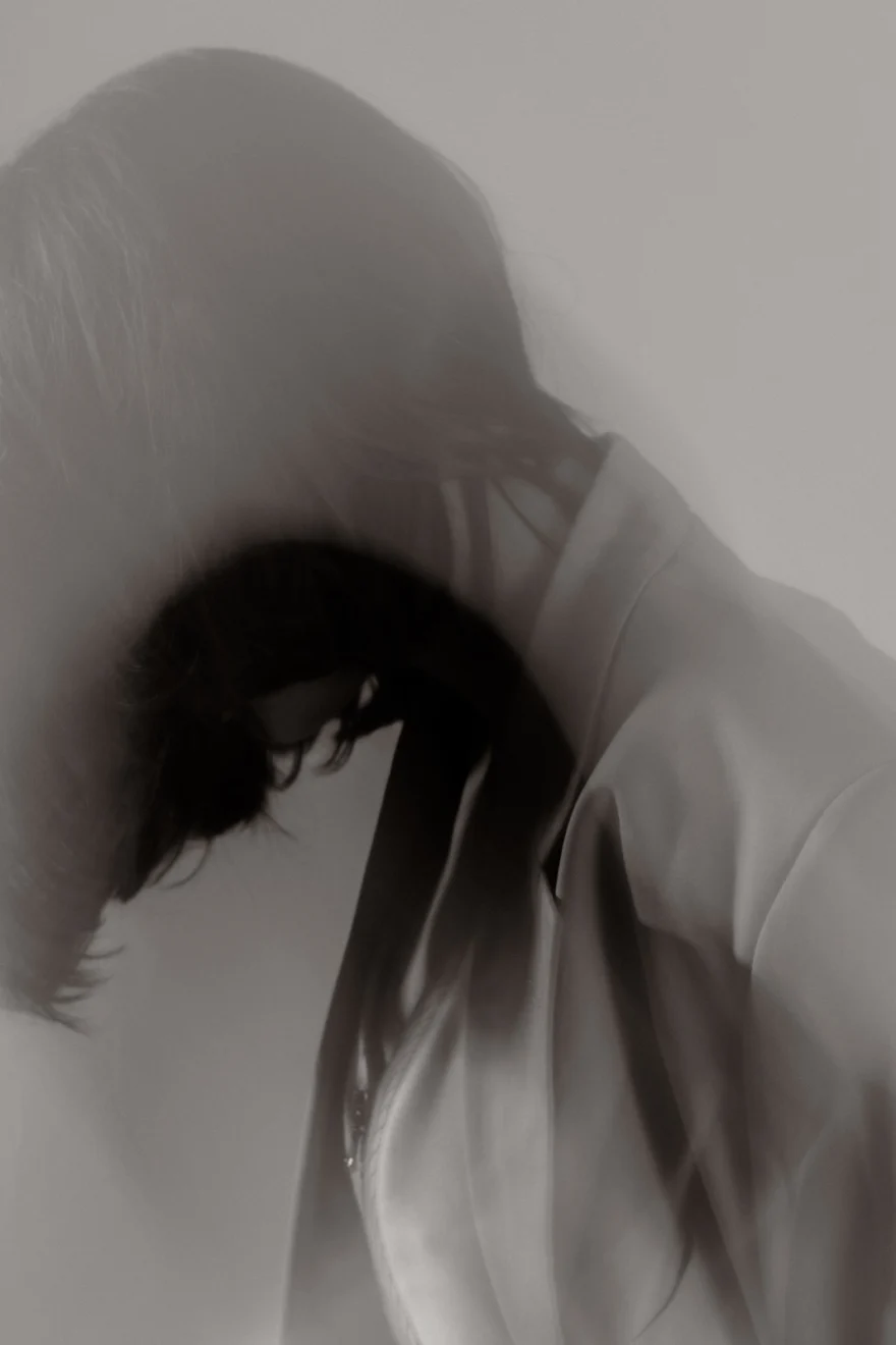 Model with head bowed under a fur-trimmed hood, soft focus, Sabina personal project photographed by Ina Cenusa