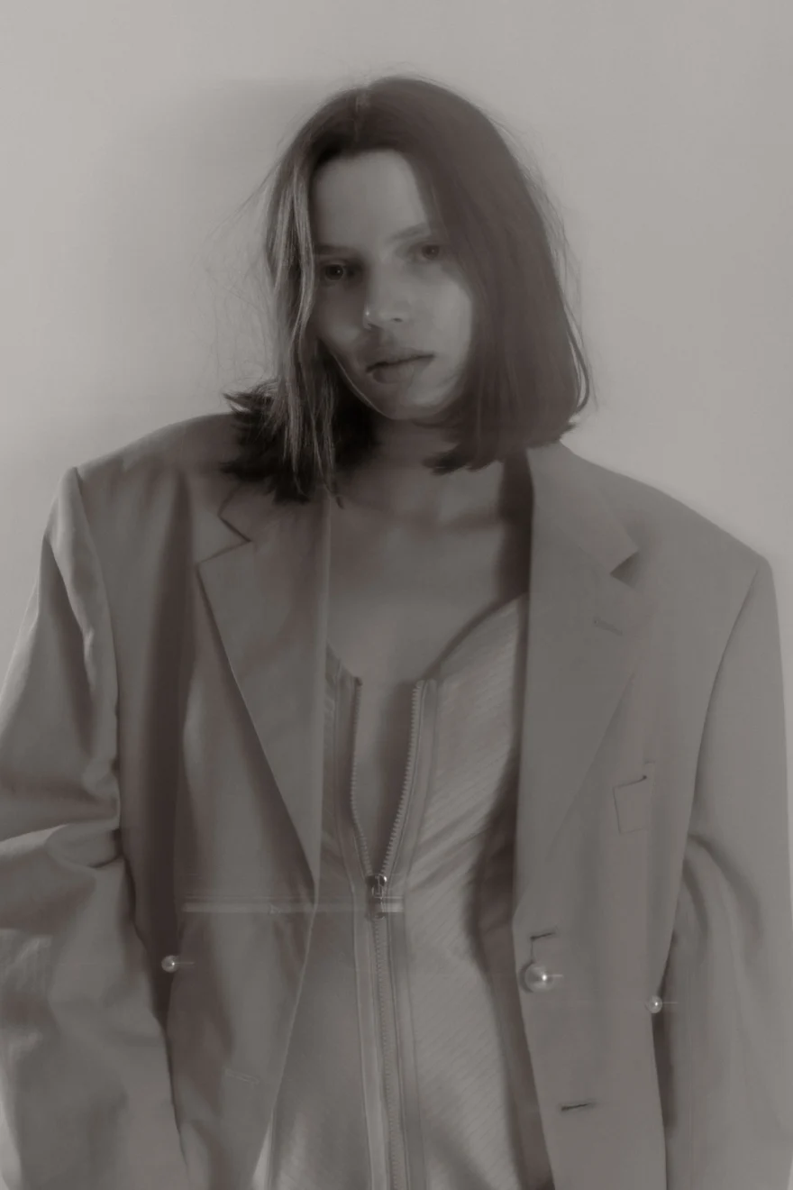 Model in an oversized pale blazer, soft desaturated studio portrait, Sabina personal project photographed by Ina Cenusa