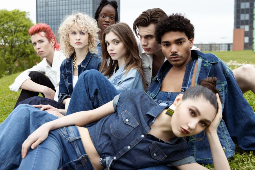 Group of models in denim seated on the grass, Carrera Jeans campaign photographed by Ina Cenusa
