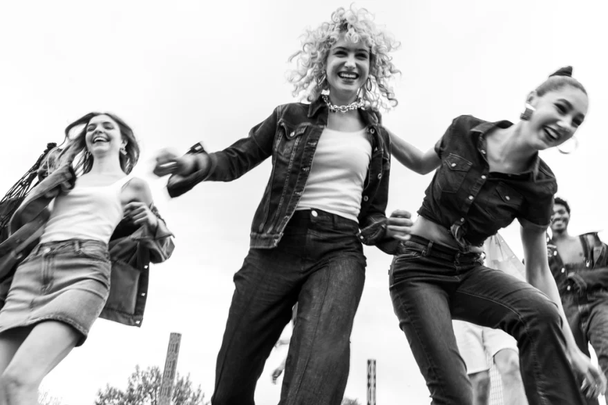 Black and white low-angle shot of models jumping in denim, Carrera Jeans campaign photographed by Ina Cenusa