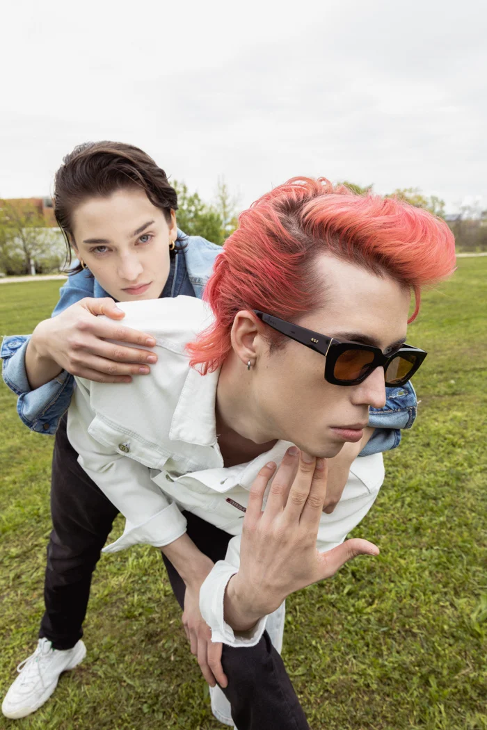 Two models playing piggyback on the grass seen from above, Carrera Jeans campaign photographed by Ina Cenusa