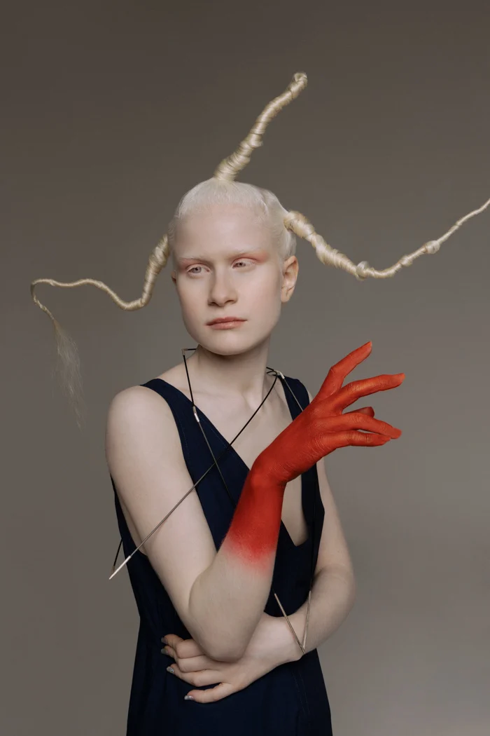 Profile of a model in a black dress with long braids and a red-painted hand, SHOT Magazine editorial photographed by Ina Cenusa
