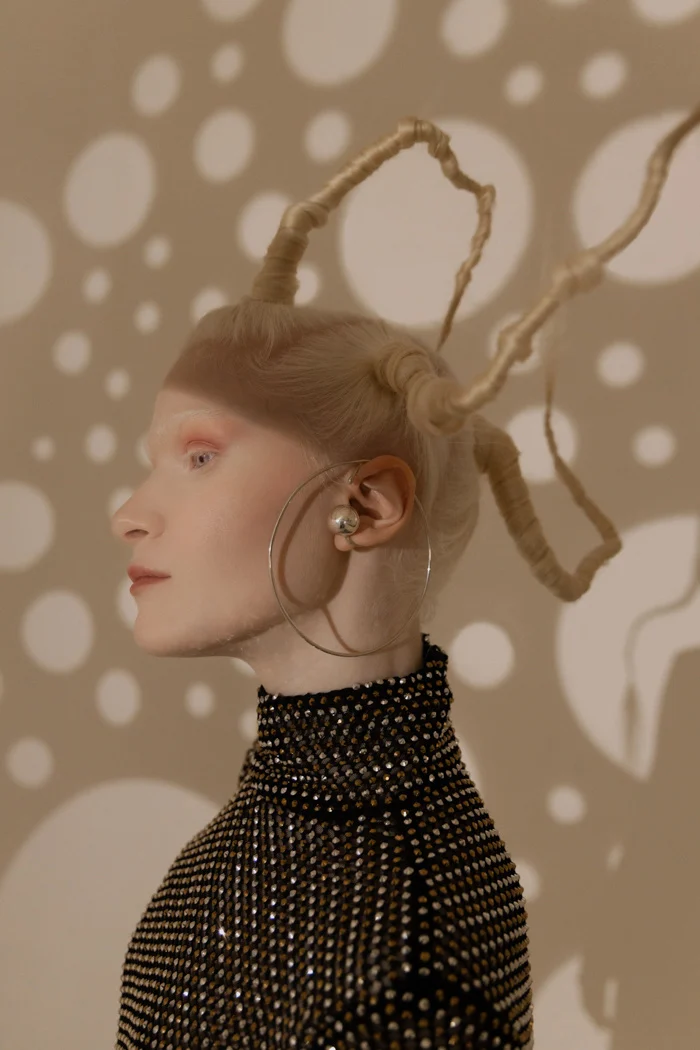 Profile portrait with sculptural braids against a projected polka-dot light, SHOT Magazine editorial photographed by Ina Cenusa