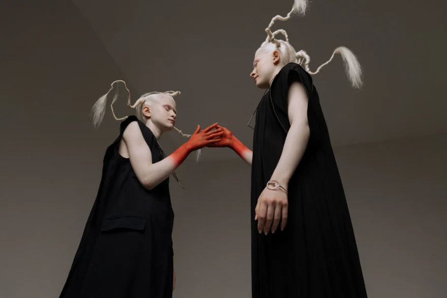 Two models facing each other in black capes, hands joined and painted red, SHOT Magazine editorial photographed by Ina Cenusa