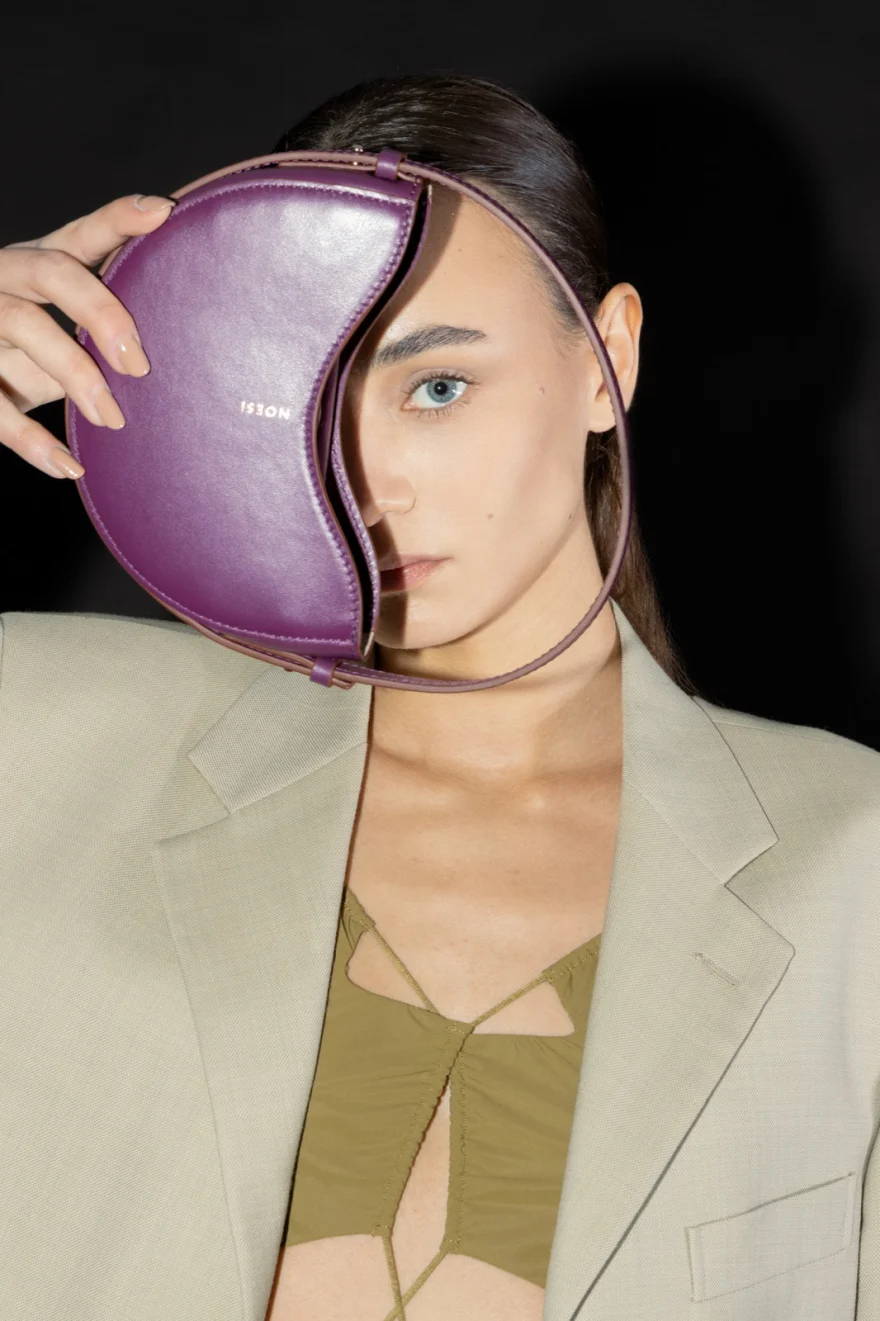 Model holding a purple leather bag across her face, Noesi campaign photographed by Ina Cenusa