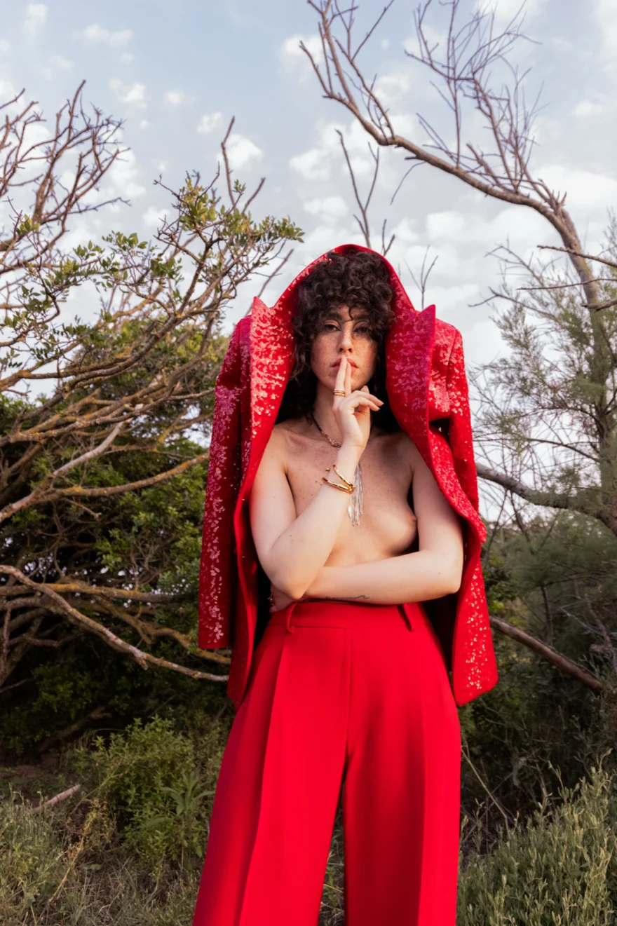 Model in a red hooded Ermanno Scervino look among bare branches, SHOT Magazine editorial photographed by Ina Cenusa