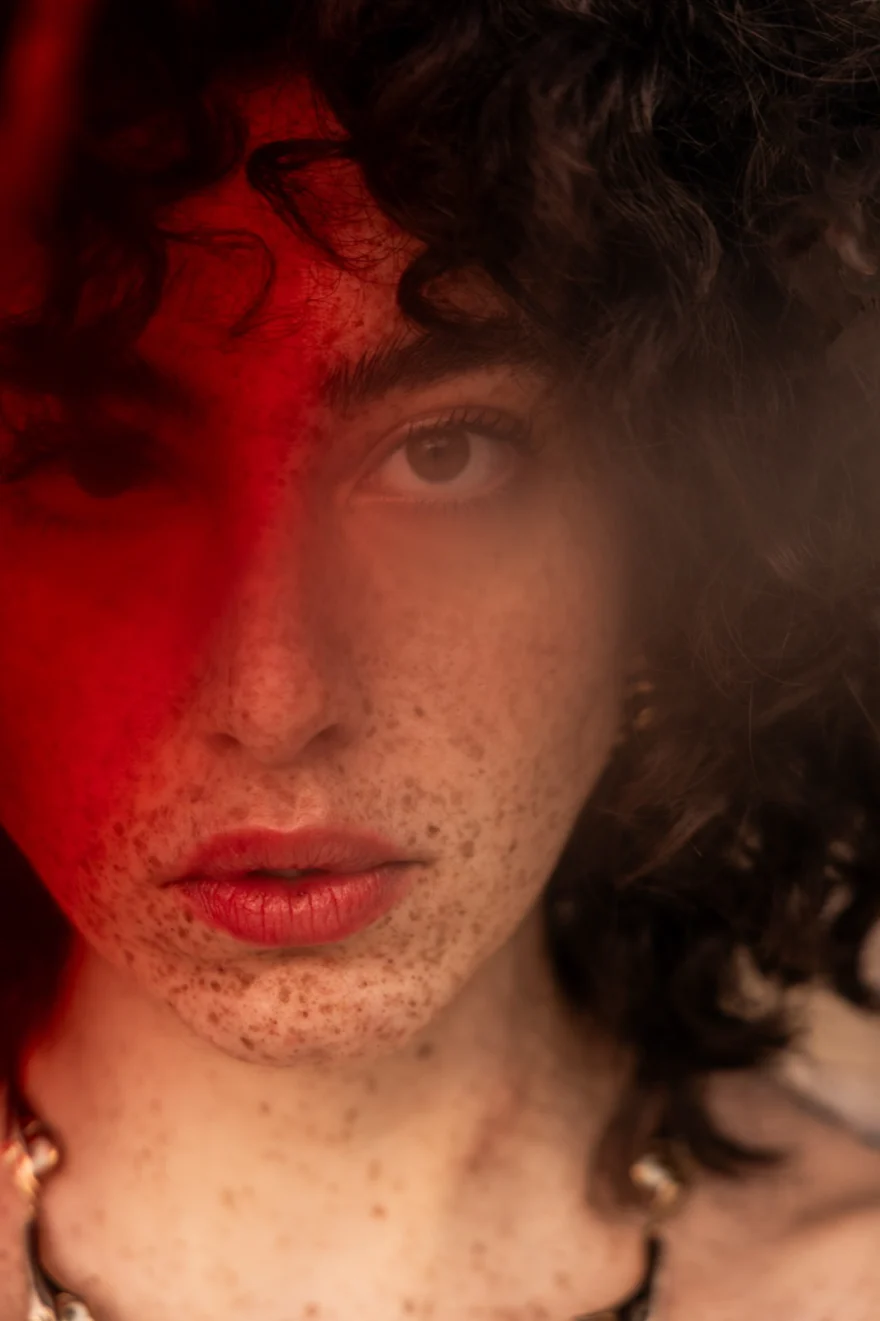 Close-up portrait with red light falling across half the face, SHOT Magazine editorial photographed by Ina Cenusa