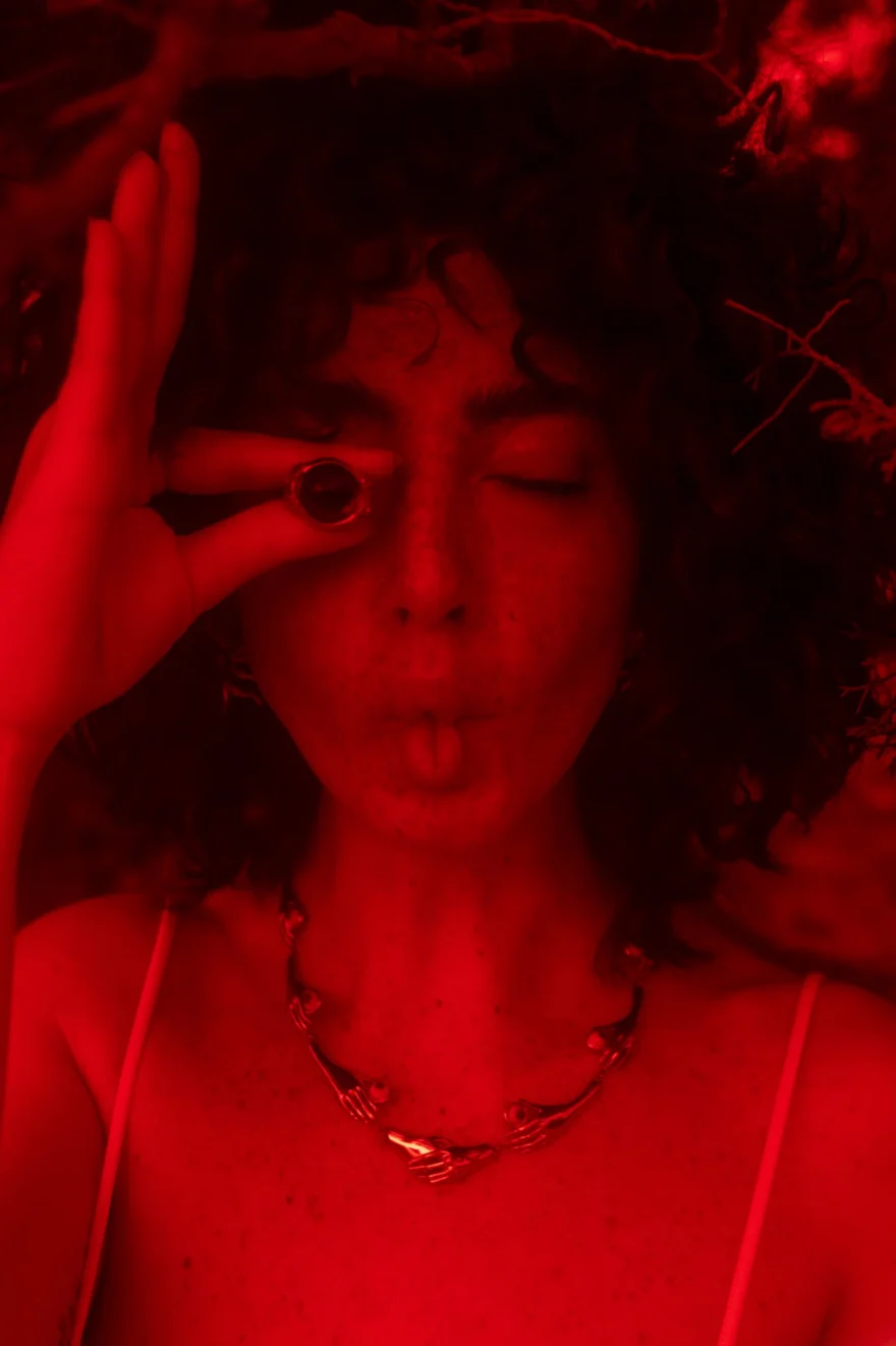 Portrait bathed in red light, hand raised with a ring to the eye, SHOT Magazine editorial photographed by Ina Cenusa