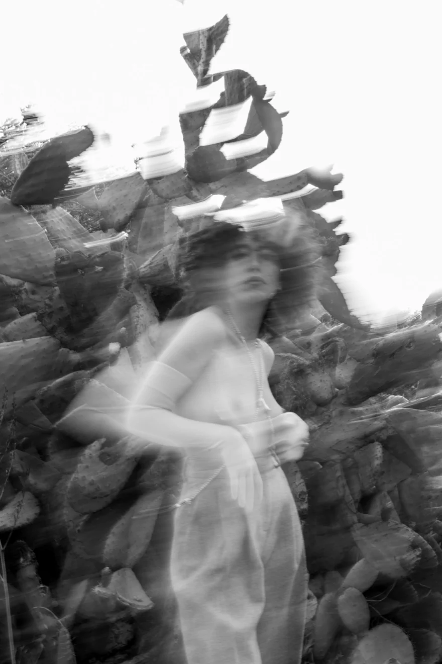 Black and white long-exposure figure moving against a rocky wall, SHOT Magazine editorial photographed by Ina Cenusa