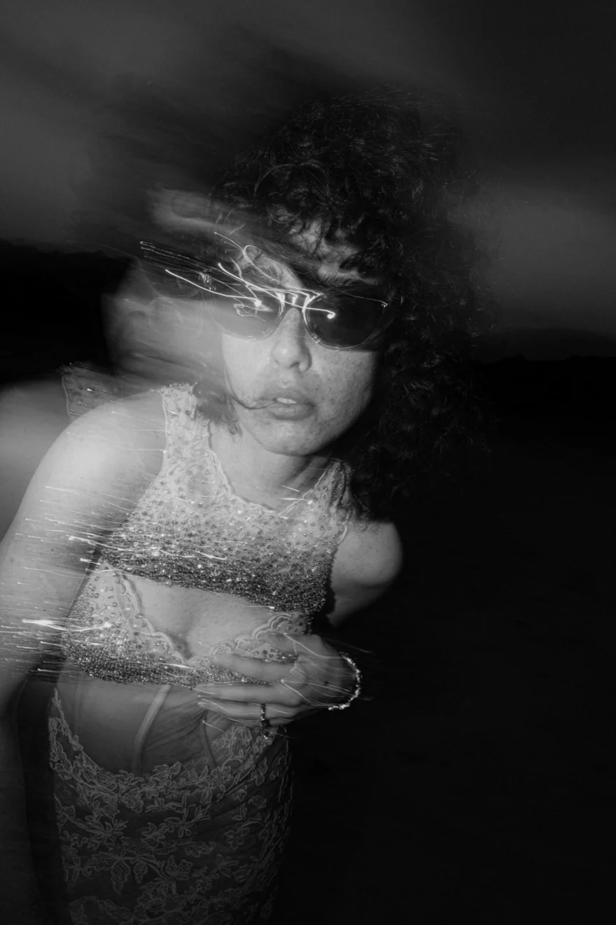 Black and white motion-blurred night portrait in a sequinned dress and sunglasses, SHOT Magazine editorial photographed by Ina Cenusa