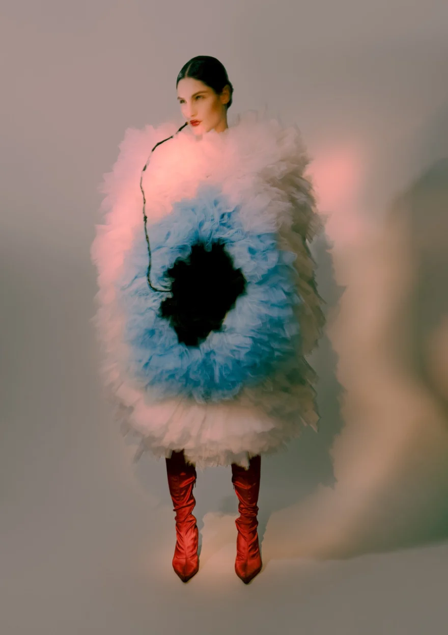 Model in a sculptural pale blue tulle costume shaped like an eye, with red boots, SHOT Magazine editorial photographed by Ina Cenusa