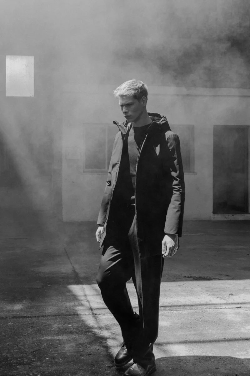 Black and white figure walking through mist in a warehouse, Mabrun campaign photographed by Ina Cenusa