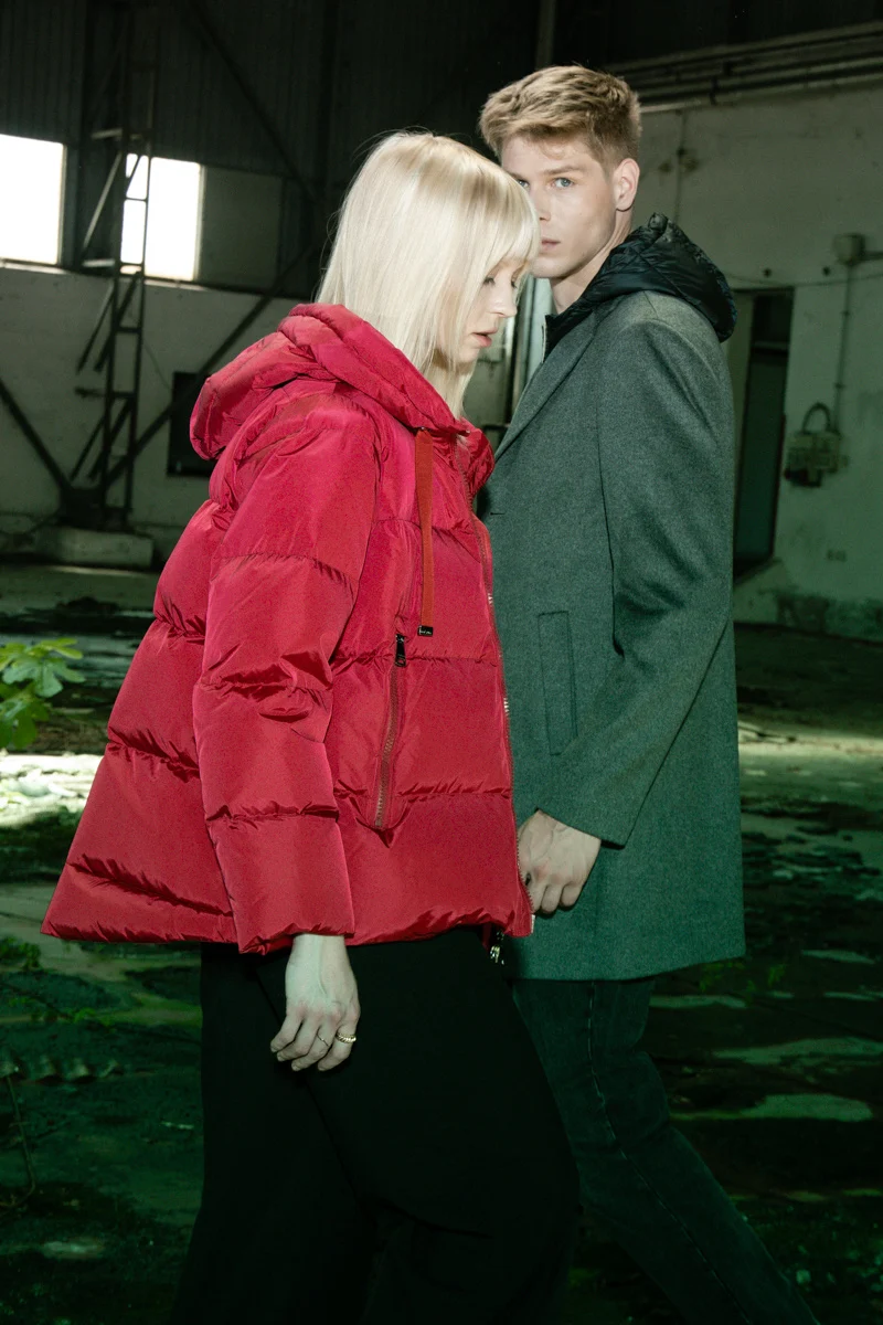Two models in red and green padded jackets in a derelict interior, Mabrun campaign photographed by Ina Cenusa