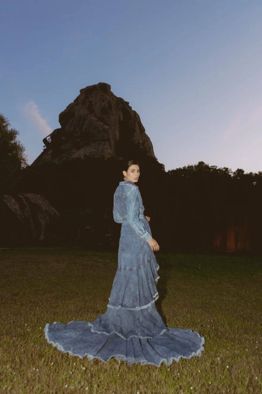 Model in a blue lace gown with a long train at dusk below the rocks, SHOT Magazine editorial photographed by Ina Cenusa