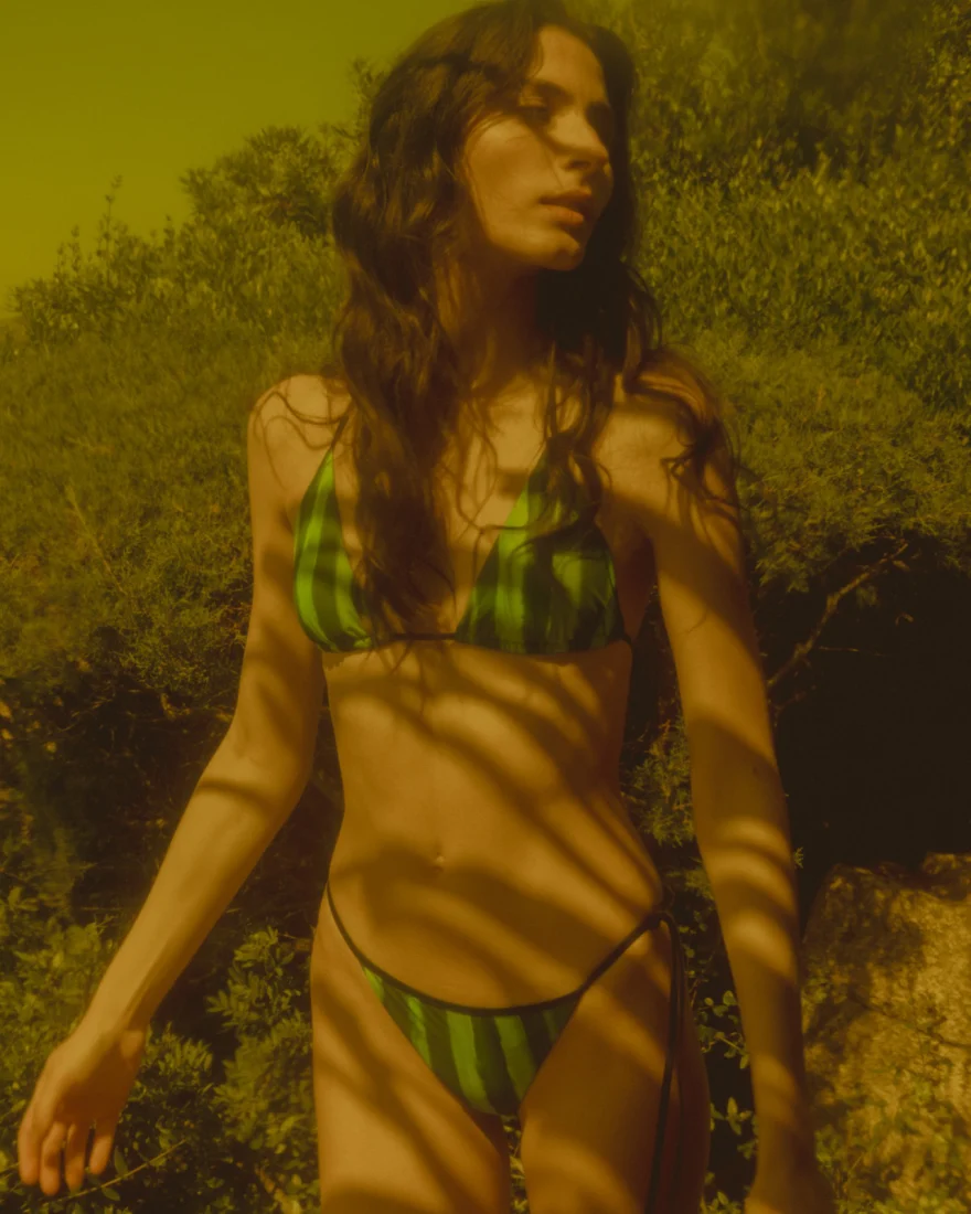 Model in a green striped bikini in warm golden light against the scrub, SHOT Magazine editorial photographed by Ina Cenusa