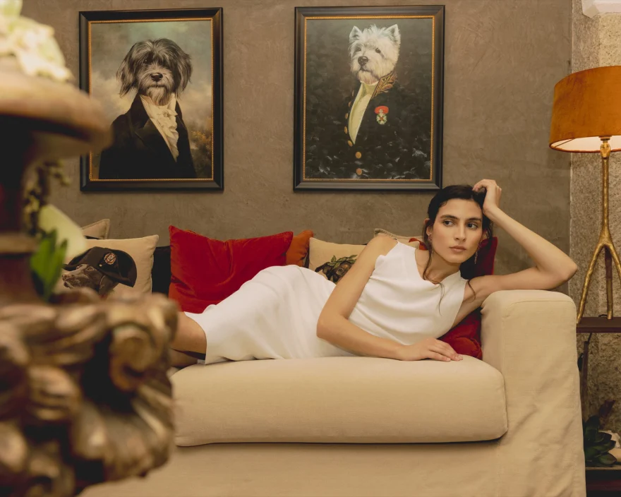 Model reclining on a sofa beneath framed dog portraits in the resort interior, SHOT Magazine editorial photographed by Ina Cenusa