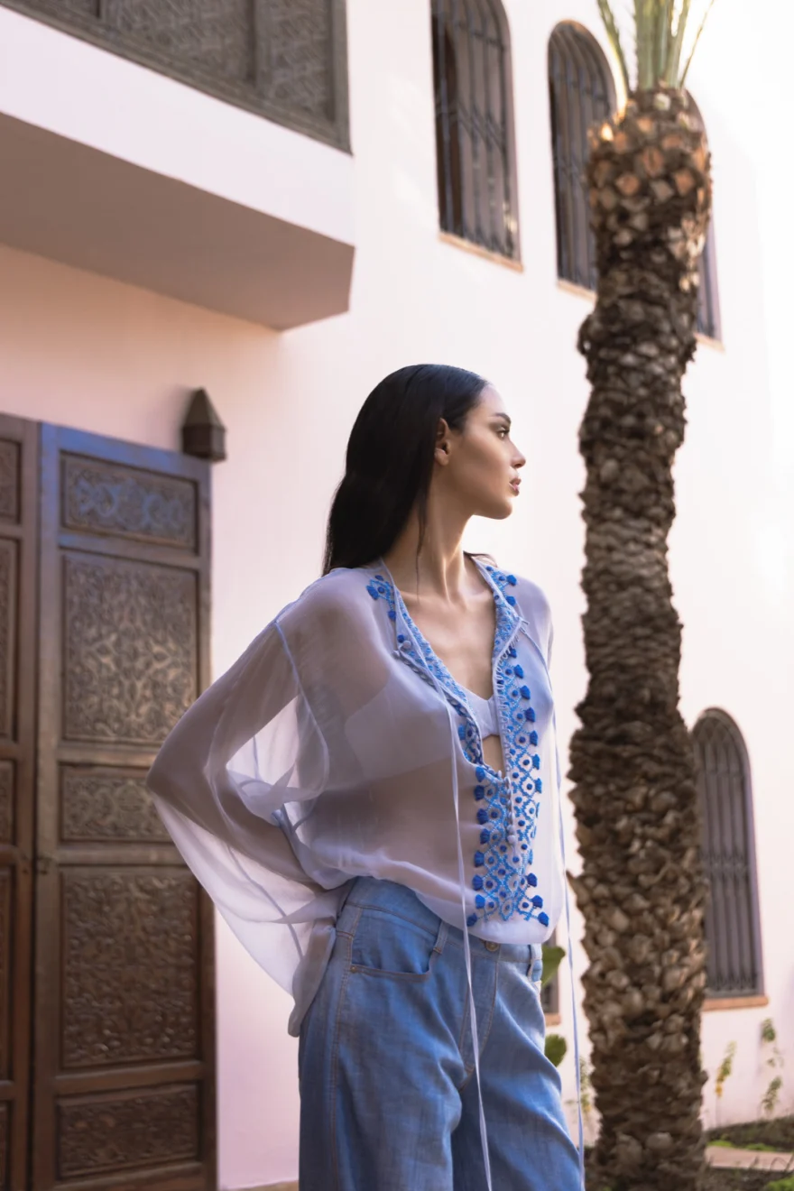 Model in a blush pleated gown framed by a carved doorway, Ermanno Scervino campaign photographed by Ina Cenusa