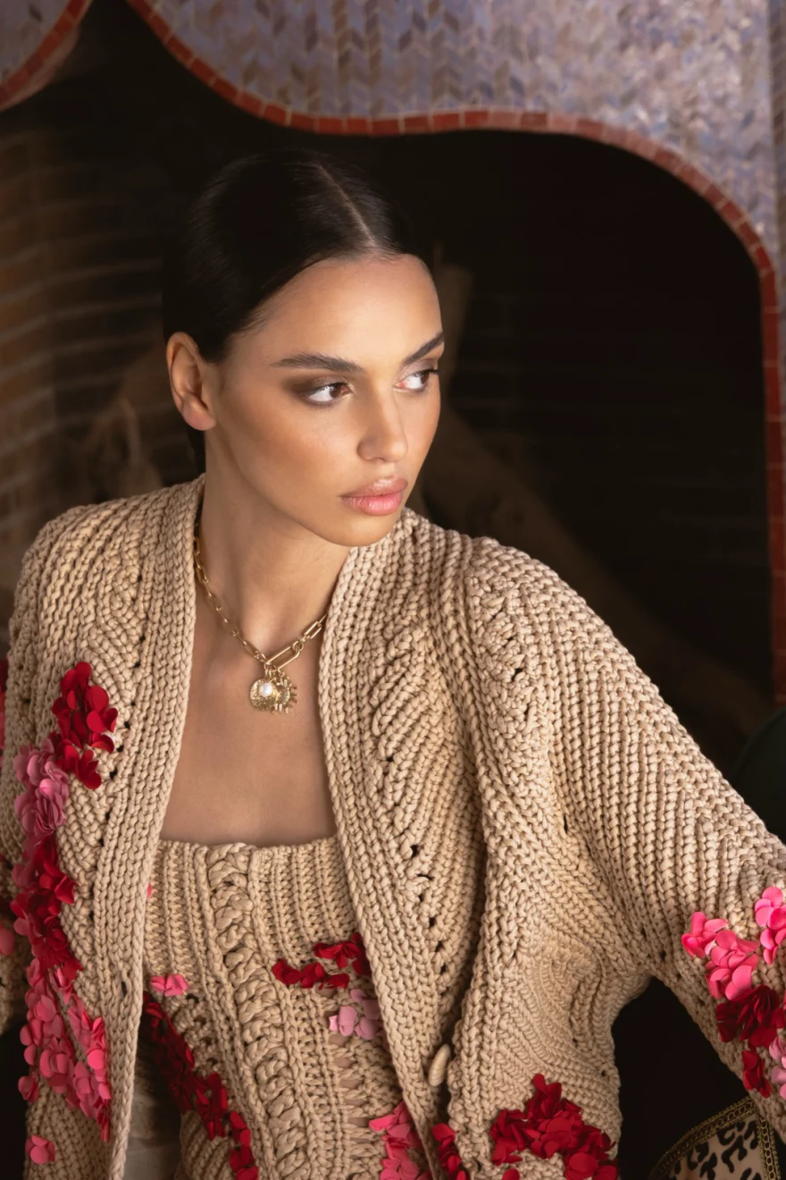 Portrait in an embroidered knit cardigan against a carved wall, Ermanno Scervino campaign photographed by Ina Cenusa