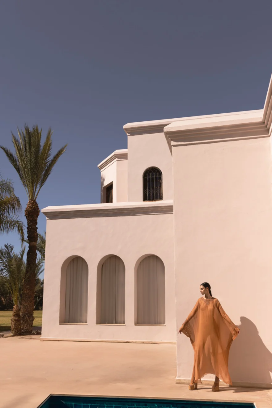 Distant figure in camel beside a white villa in Marrakech and palms, Ermanno Scervino campaign photographed by Ina Cenusa