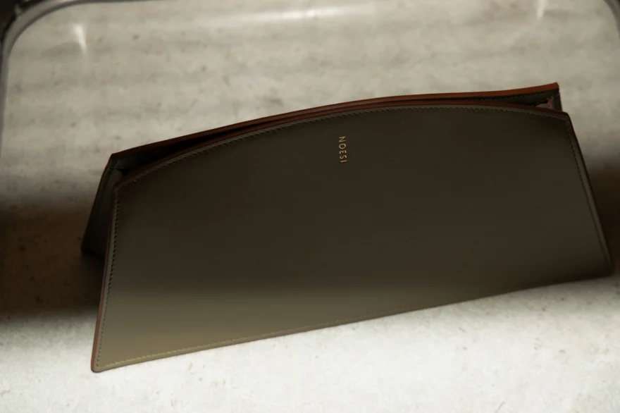 Still life of an olive leather clutch, Noesi campaign photographed by Ina Cenusa