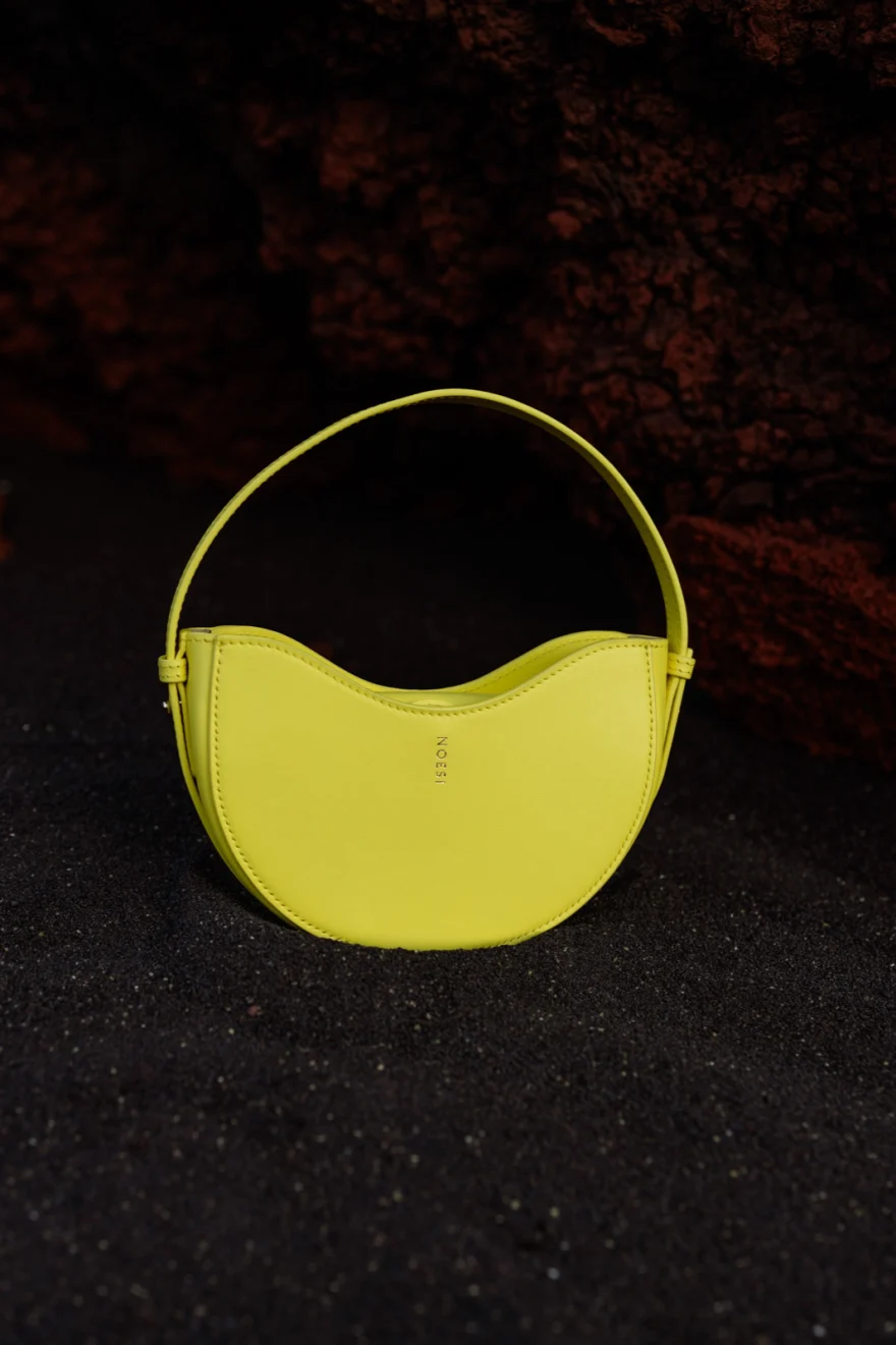 Yellow leather bag on black volcanic rock, Noesi campaign photographed by Ina Cenusa
