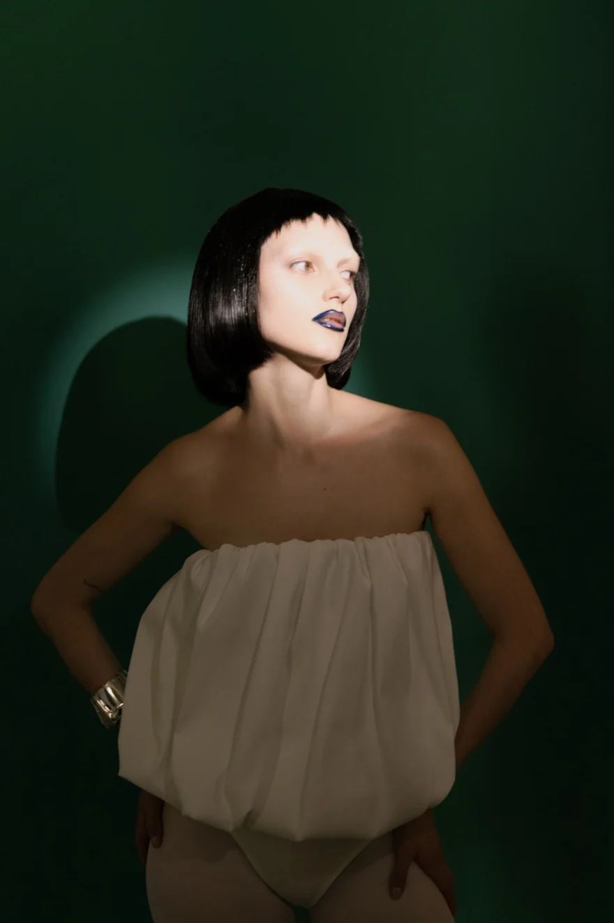 Model in a beige bandeau top against a deep green backdrop, SHOT Magazine editorial photographed by Ina Cenusa