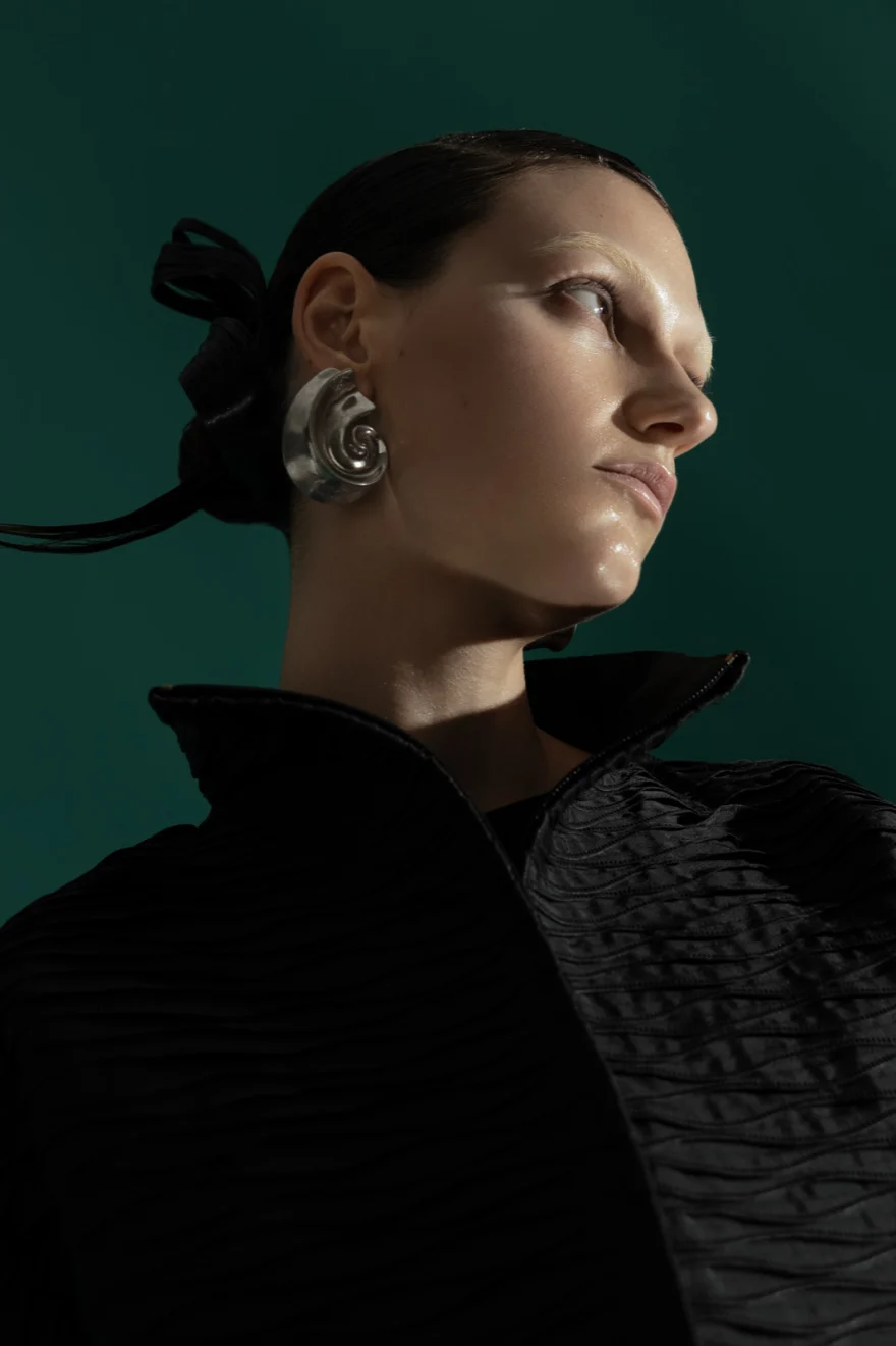 Profile portrait in a black quilted high-collar look with silver earrings, SHOT Magazine editorial photographed by Ina Cenusa