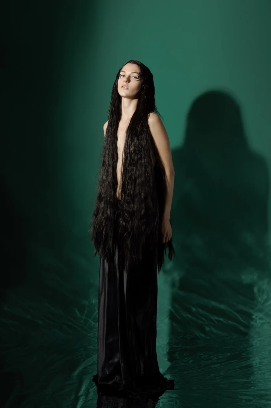 Model in a long black gown with floor-length hair against green, SHOT Magazine editorial photographed by Ina Cenusa