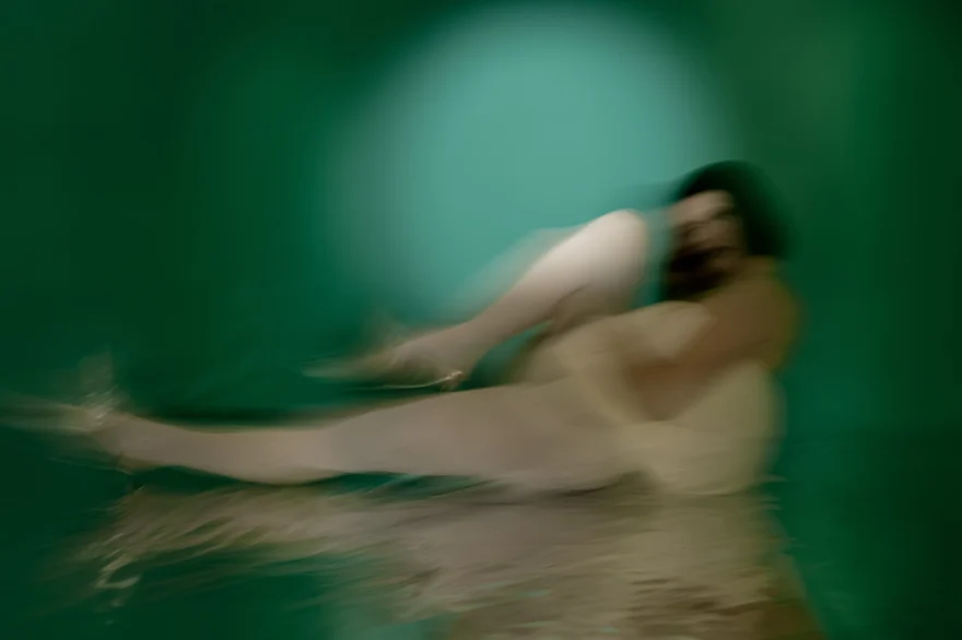 Blurred reclining figure on a reflective green surface, SHOT Magazine editorial photographed by Ina Cenusa