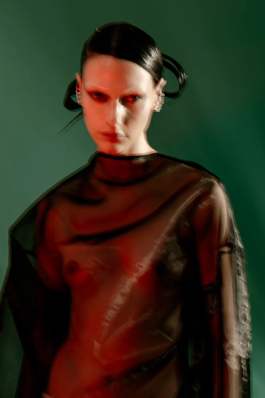 Model in a sheer black top lit in red and green, closing image of Holographic Haze, SHOT Magazine editorial photographed by Ina Cenusa